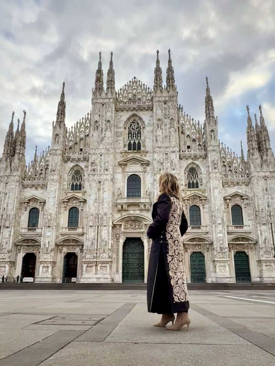 Embroidered black coat from the Milan 2025 collection, photographed at the Duomo